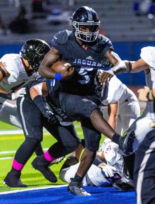 Desert Pines RB Greg Burrell (5) scores over Faith Lutheran's defense for a score during the fi ...