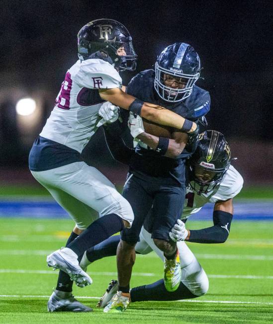 Desert Pines WR Trey Jackson (22) is stopped after a return by Faith Lutheran's LB Cole Keith ( ...