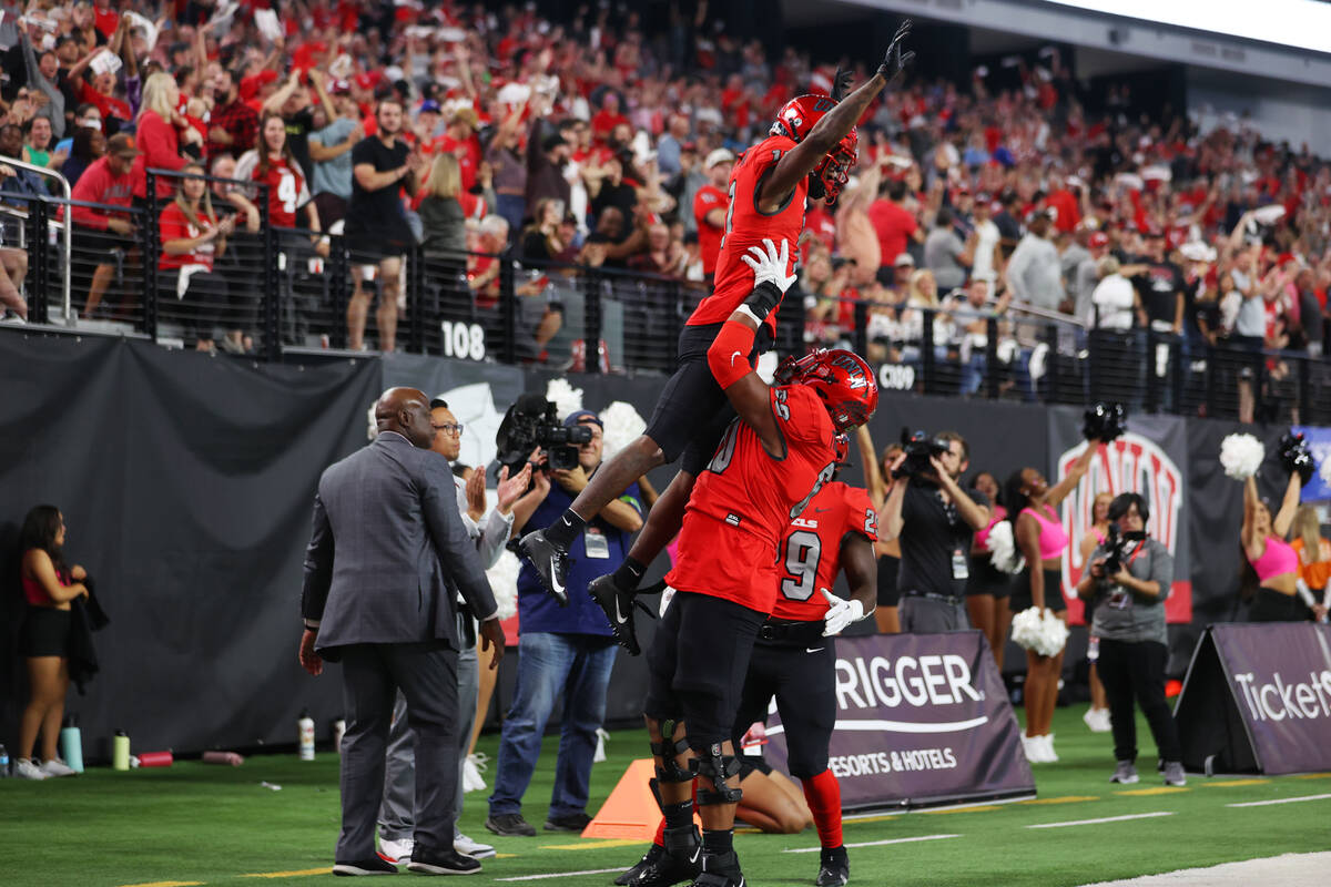 UNLV Rebels wide receiver Ricky White (11) celebrates his touchdown with offensive lineman Aman ...