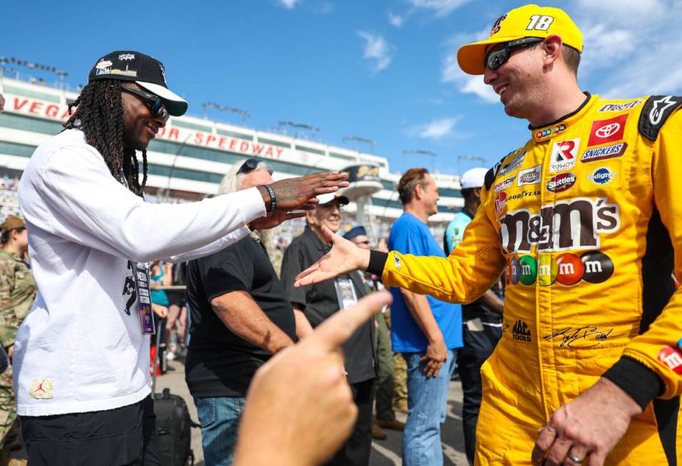 Honorary pace car driver Davante Adams of the Raiders, left, greets driver Kyle Busch before th ...