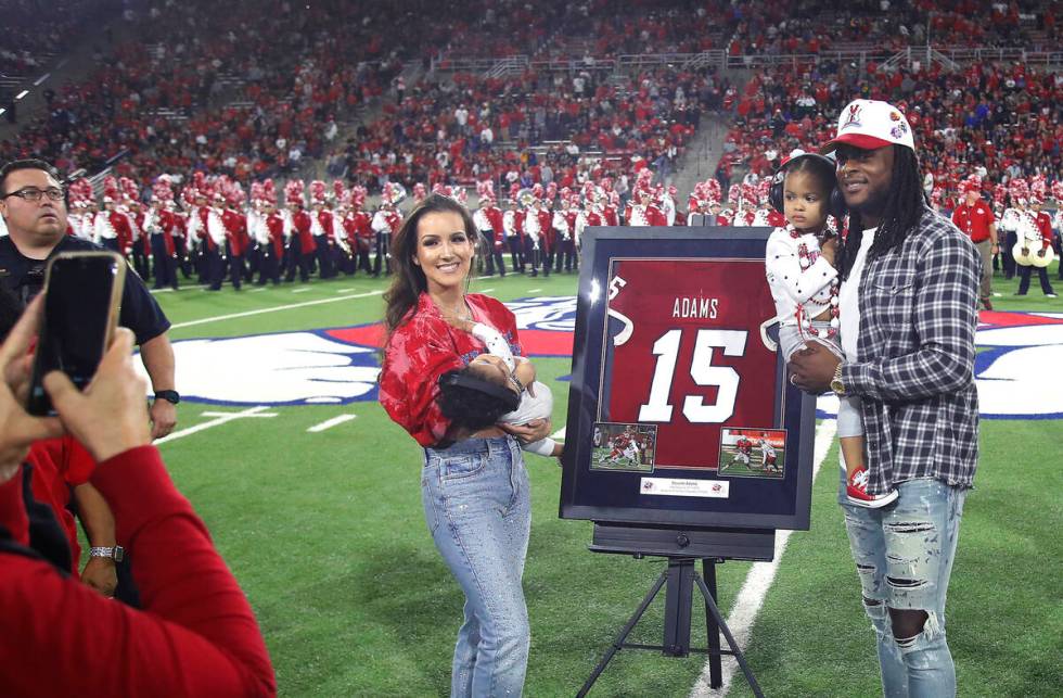 Las Vegas Raiders' Davante Adams, right, a former Fresno State player, has his jersey number re ...