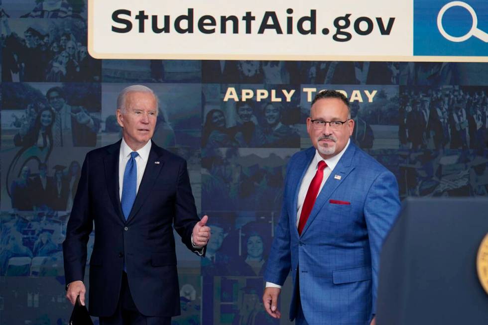 President Joe Biden answers questions with Education Secretary Miguel Cardona as they leave an ...