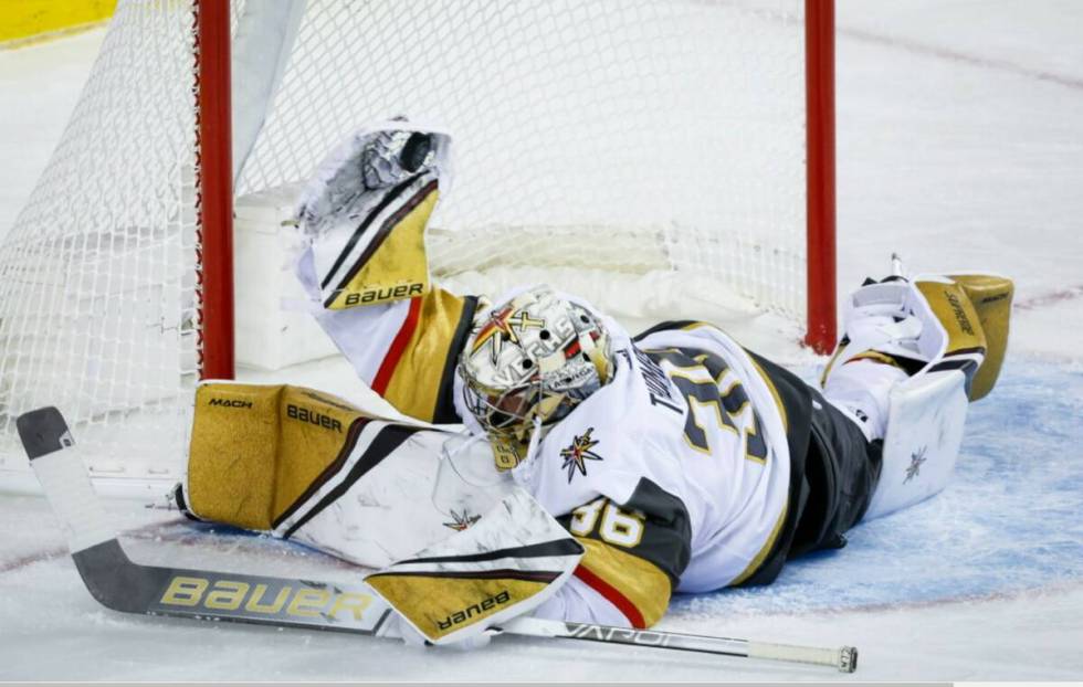 Vegas Golden Knights goalie Logan Thompson makes a save against the Calgary Flames during the f ...