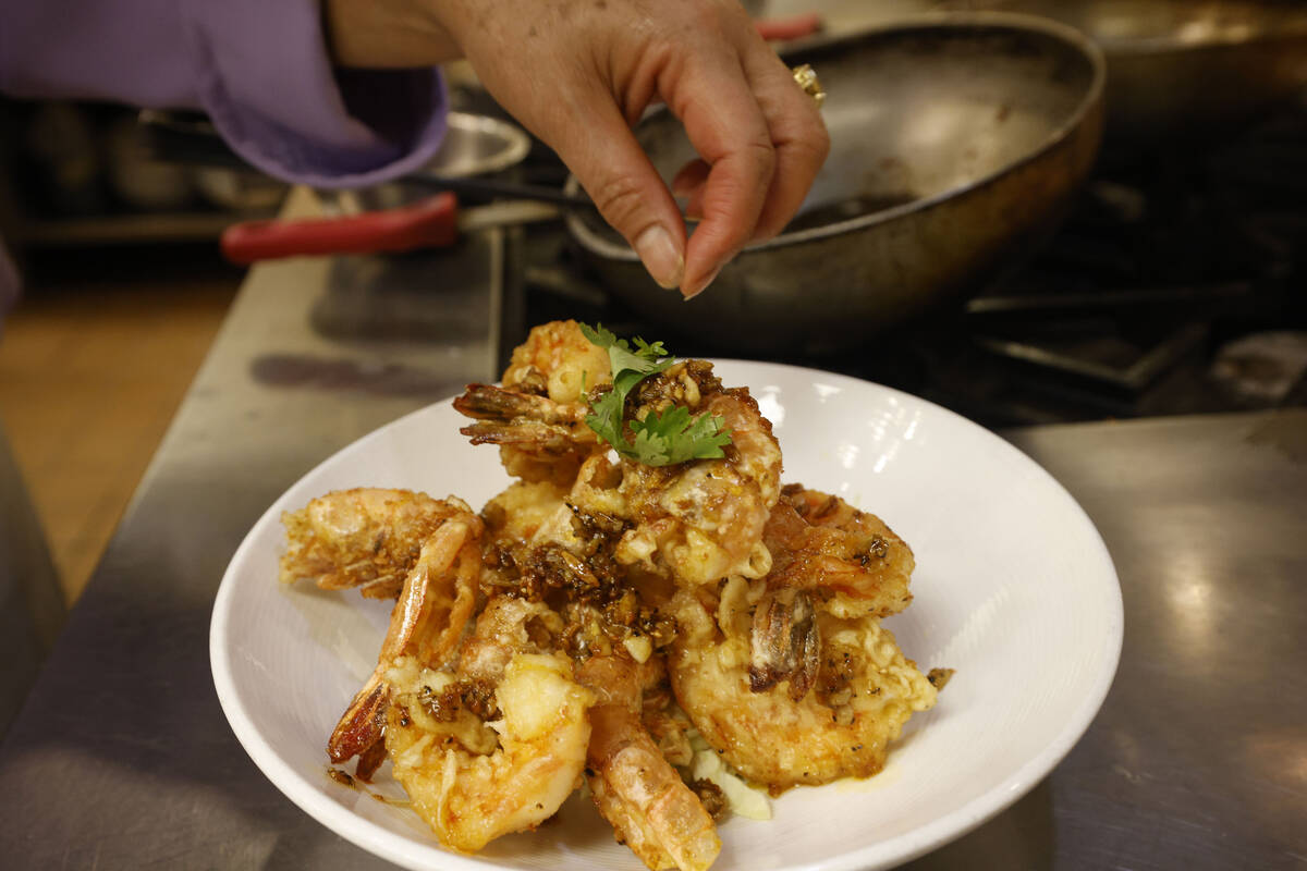 Lotus of Siam owner/chef Saipin Chutima, left, makes a dish of Garlic Prawns, Friday, July 22, ...