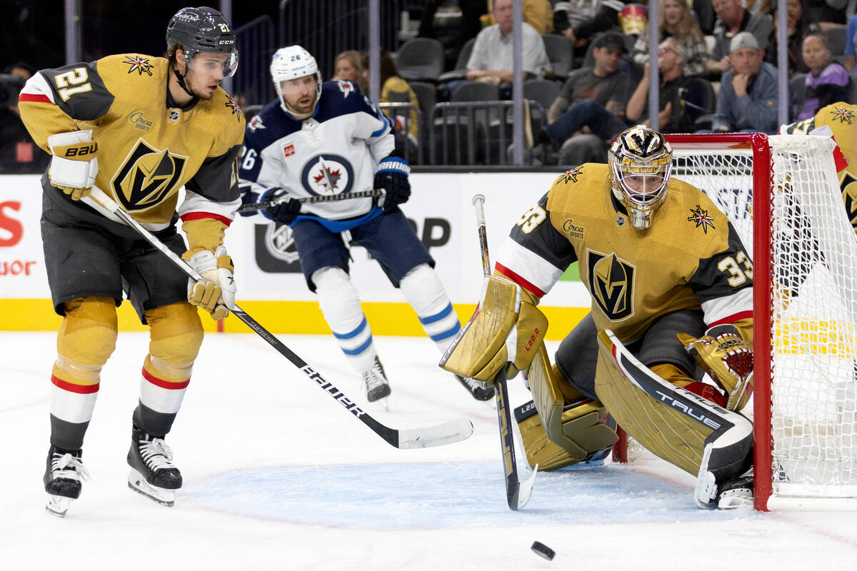 Golden Knights goaltender Adin Hill (33) prepares to save the puck while center Brett Howden (2 ...