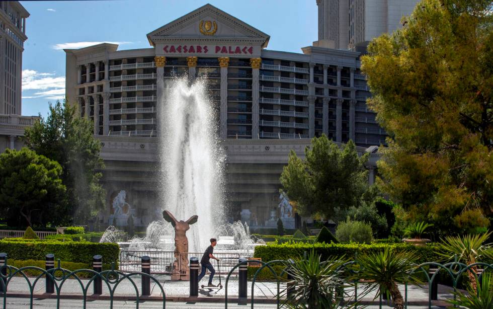 A scooter rider moves past the main Caesars Palace fountain area on Monday, May 18, 2020, in La ...