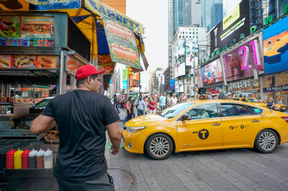 Youssef Mohamed moves his hot dog cart into his spot on 45th Street in New York's Times Square ...