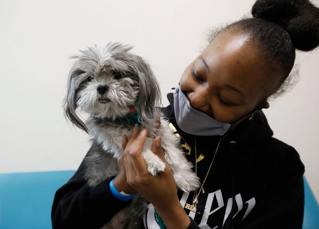 Chayiko McMillian greets her new pet dog Sassy that she and her husband, Marsean Anderson, chos ...