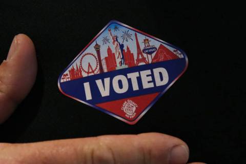 FILE - Kirk Rossmann shows off his "I Voted" sticker after casting his ballots at a polling sta ...