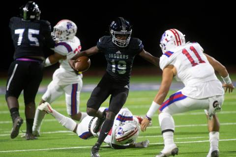 Desert Pines' Billy Ross (19) runs with the ball as Liberty's Kahekili Paaoao (11) defends duri ...