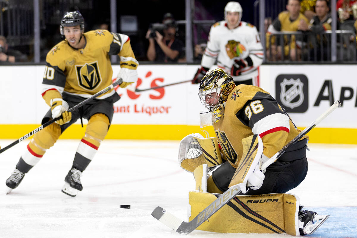 Golden Knights goaltender Logan Thompson (36) makes a save while Golden Knights center Nicolas ...