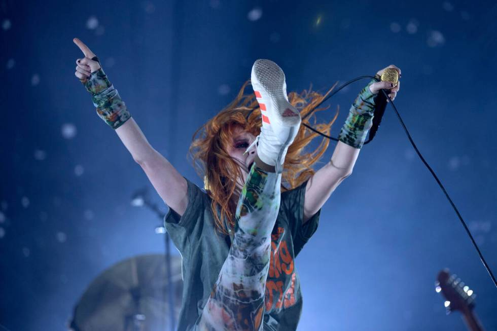 Paramore’s lead singer Hayley Williams high kicks while singing during When We Were Youn ...