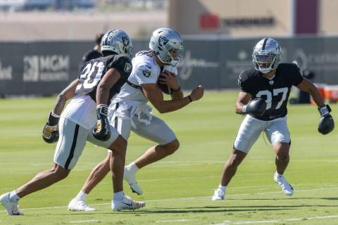 Raiders wide receiver Mack Hollins (10) tries to keep possession of the football as safety Isai ...