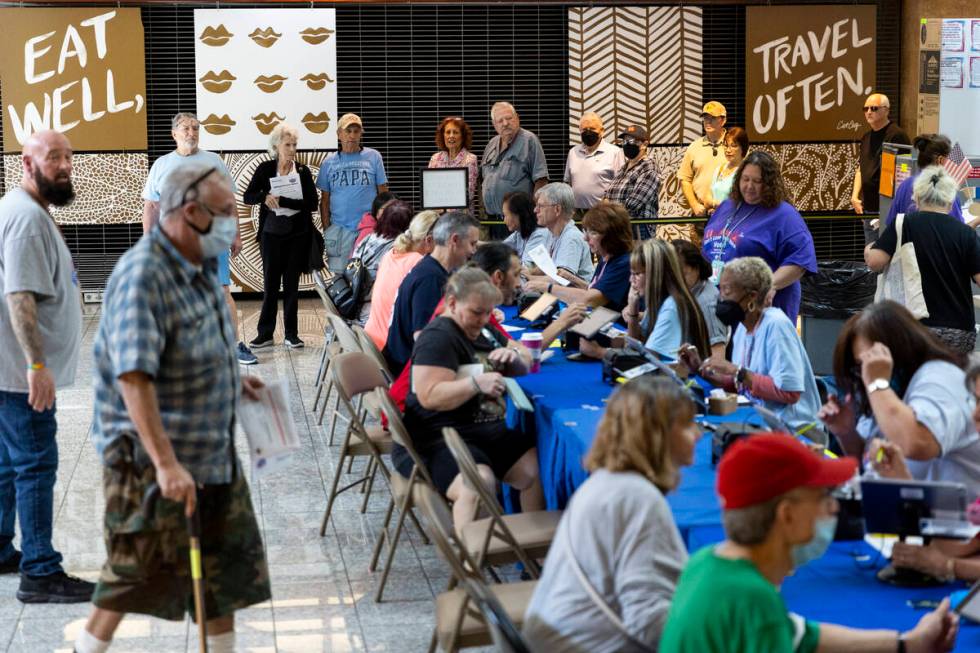 People wait in line to vote at the polling place inside of the Galleria at Sunset shopping mall ...