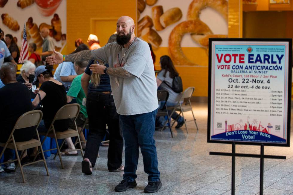 Poll worker Phil Hallond directs people at the polling place inside of the Galleria at Sunset s ...