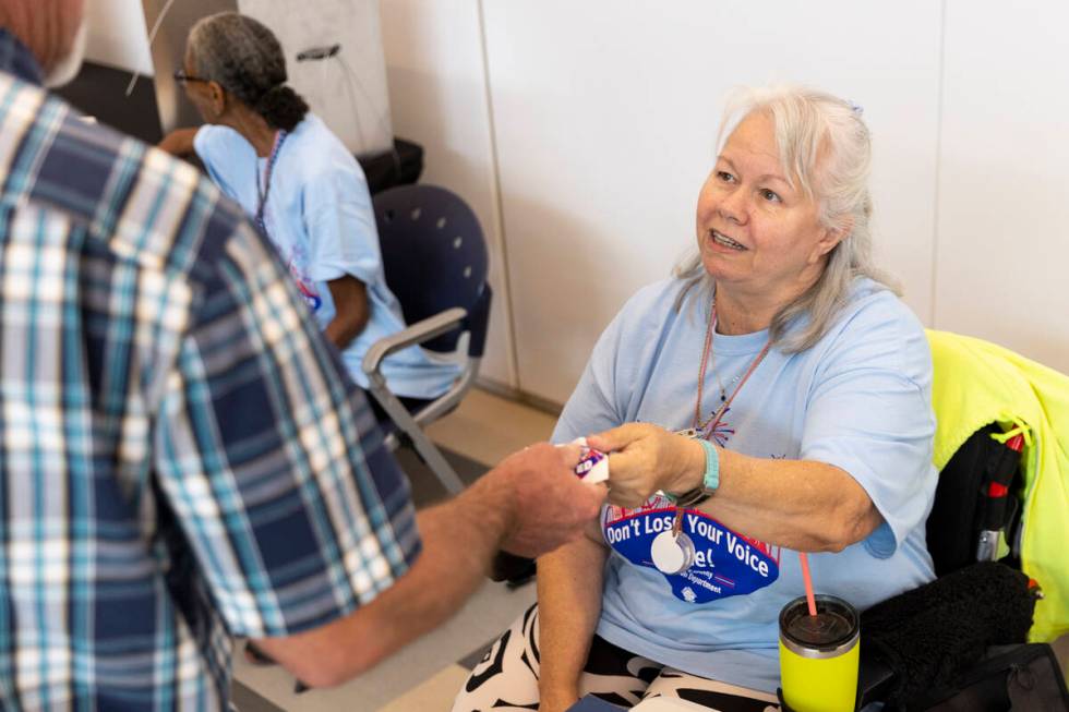 Poll worker Terry Kilne hands out an I voted sticker at the polling place inside of the East La ...