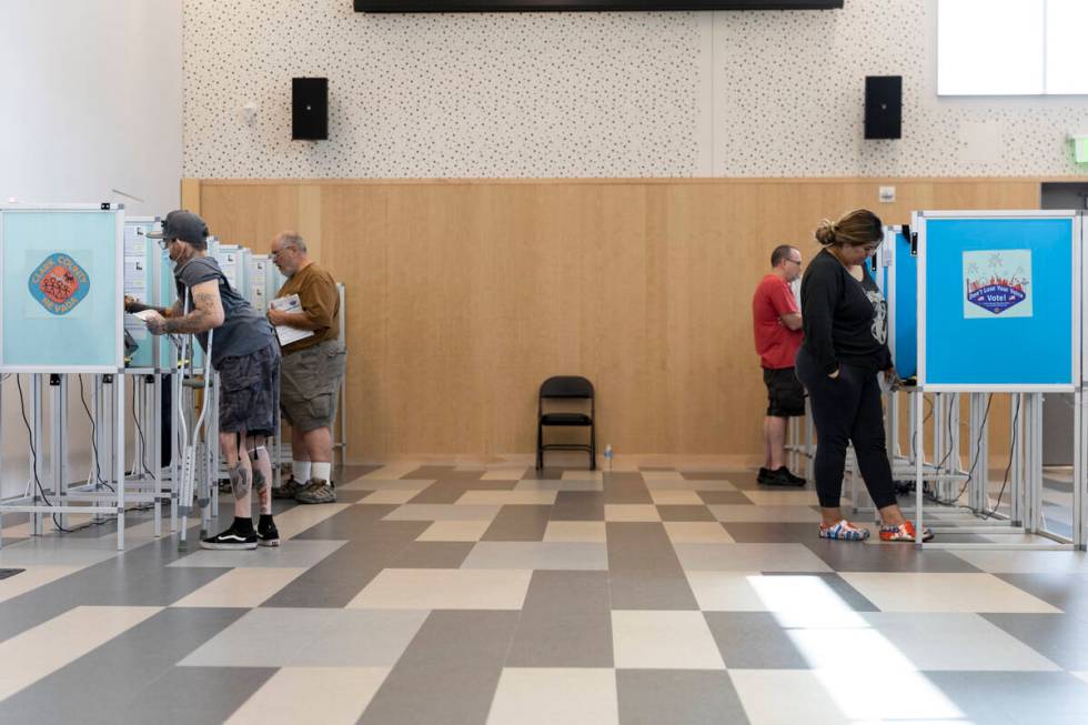 People cast their votes at the polling place inside of the East Las Vegas Library in Las Vegas, ...