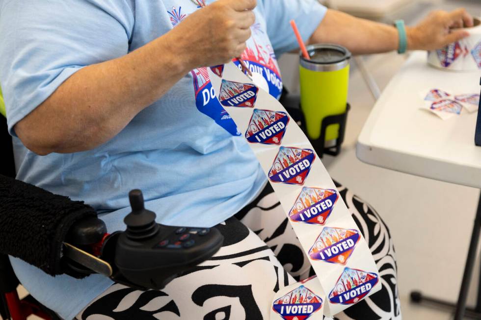 Poll worker Terry Kilne organizes her I voted stickers at the polling place inside of the East ...