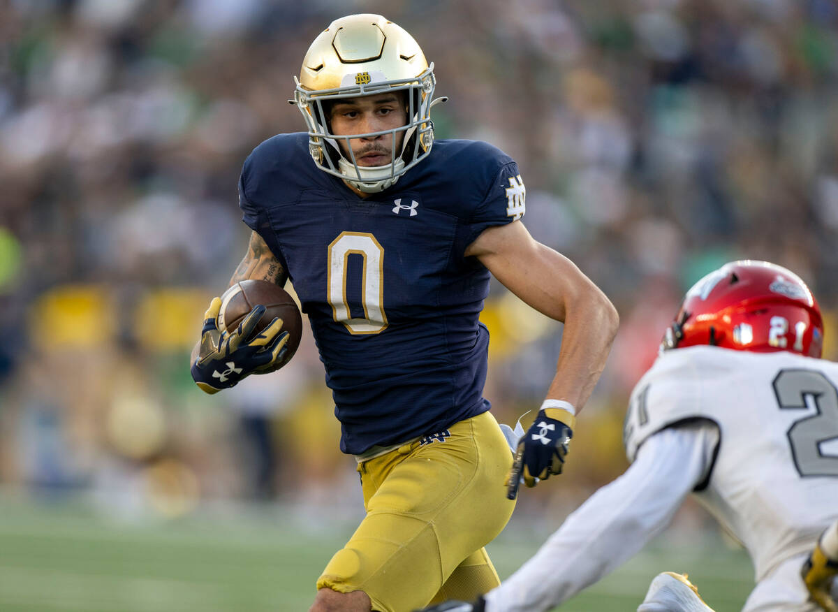 Notre Dame wide receiver Braden Lenzy (0) looks to run past UNLV defensive back Nohl Williams ( ...