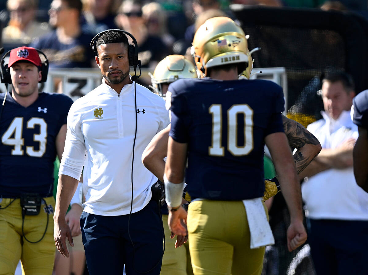 Notre Dame head coach Marcus Freeman prepares to talk with Notre Dame quarterback Drew Pyne (10 ...