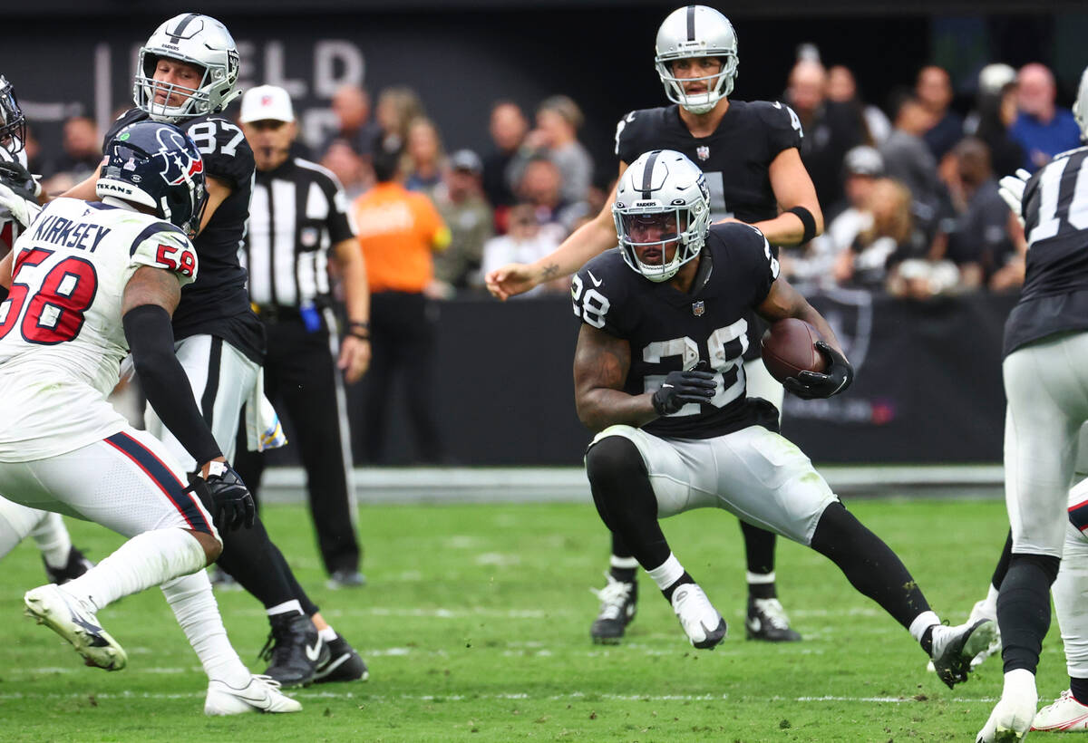 Raiders running back Josh Jacobs (28) runs the ball against the Houston Texans during the first ...