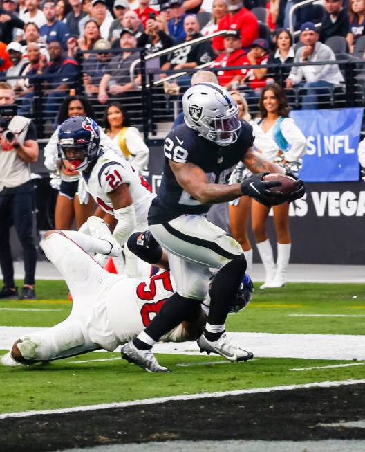 Raiders running back Josh Jacobs (28) gets past Houston Texans defensive tackle Thomas Booker I ...