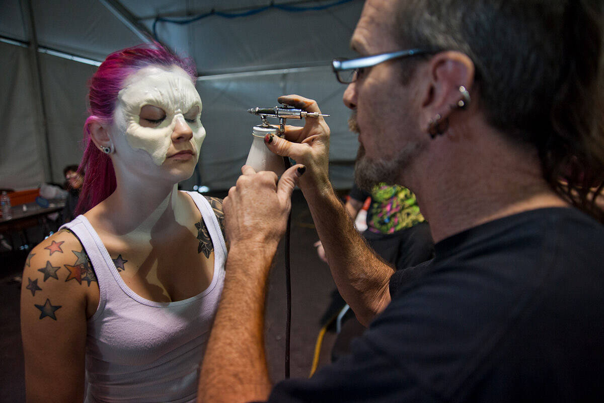 Nickie Sundin, left, gets makeup put on by body painter/artist Rob Hester for a run-through for ...