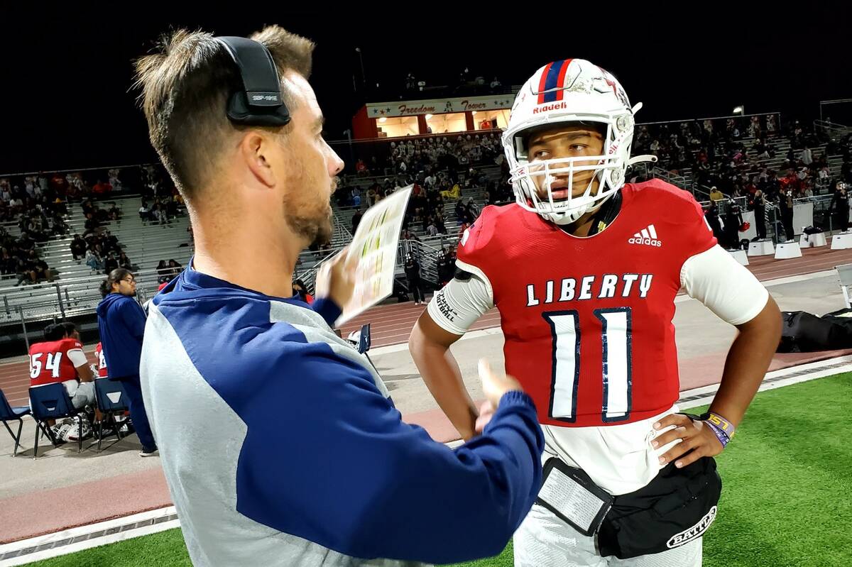 Liberty offensive coordinator Mark Bly talks with quarterback Tyrese Smith during the Patriots' ...