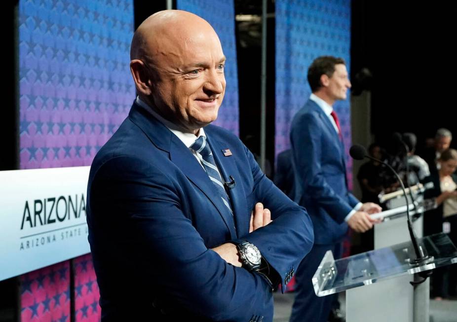 Arizona Democratic Sen. Mark Kelly, left, smiles as he stands on stage with Republican challeng ...