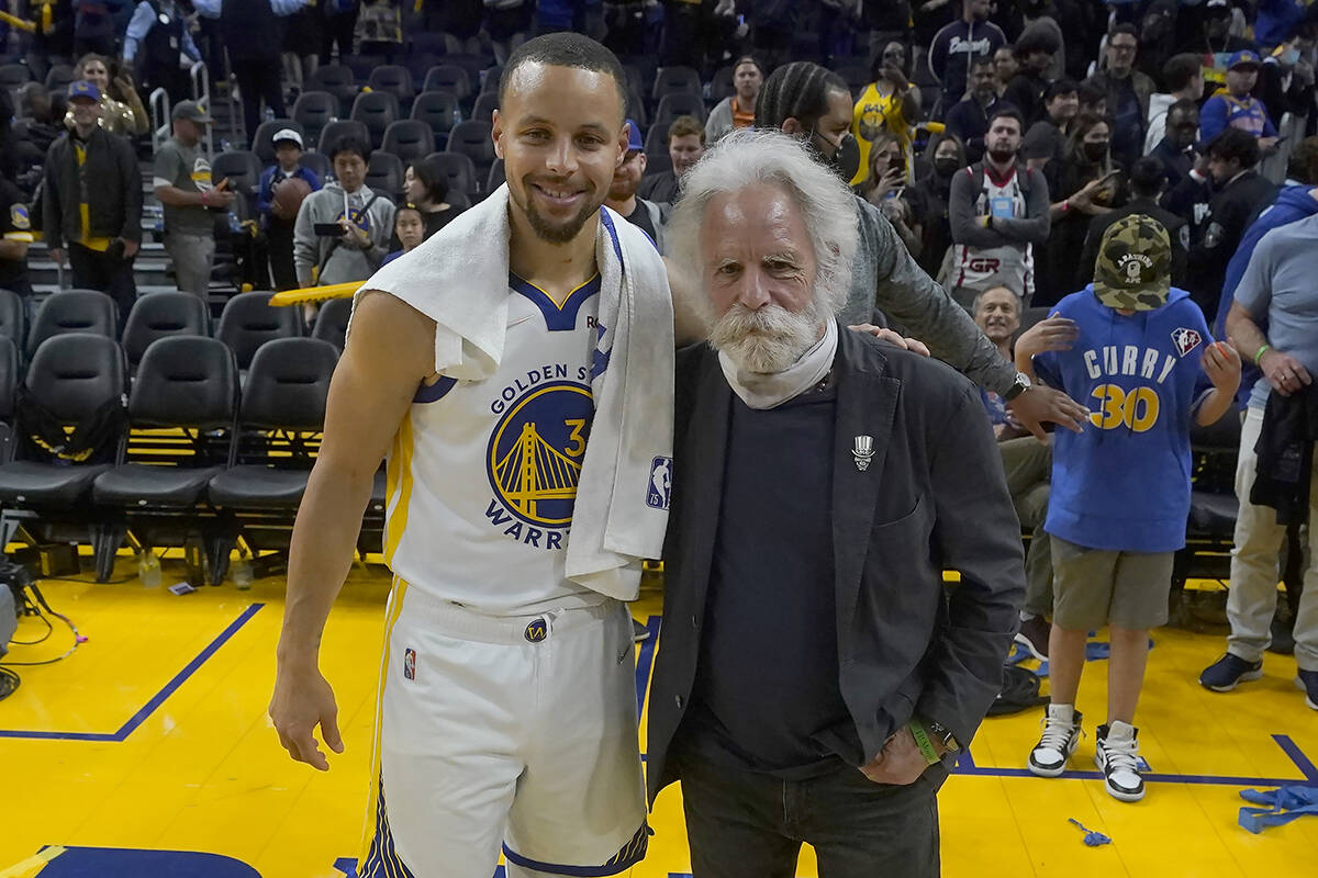 Golden State Warriors guard Stephen Curry, left, poses for photos with musician Bob Weir after ...
