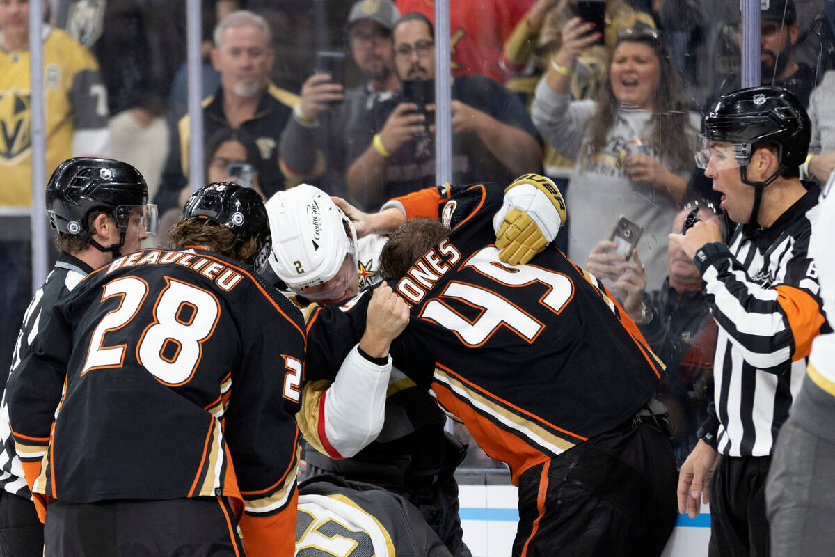 Golden Knights defenseman Zach Whitecloud (2) fights with Ducks left wing Max Jones (49) while ...