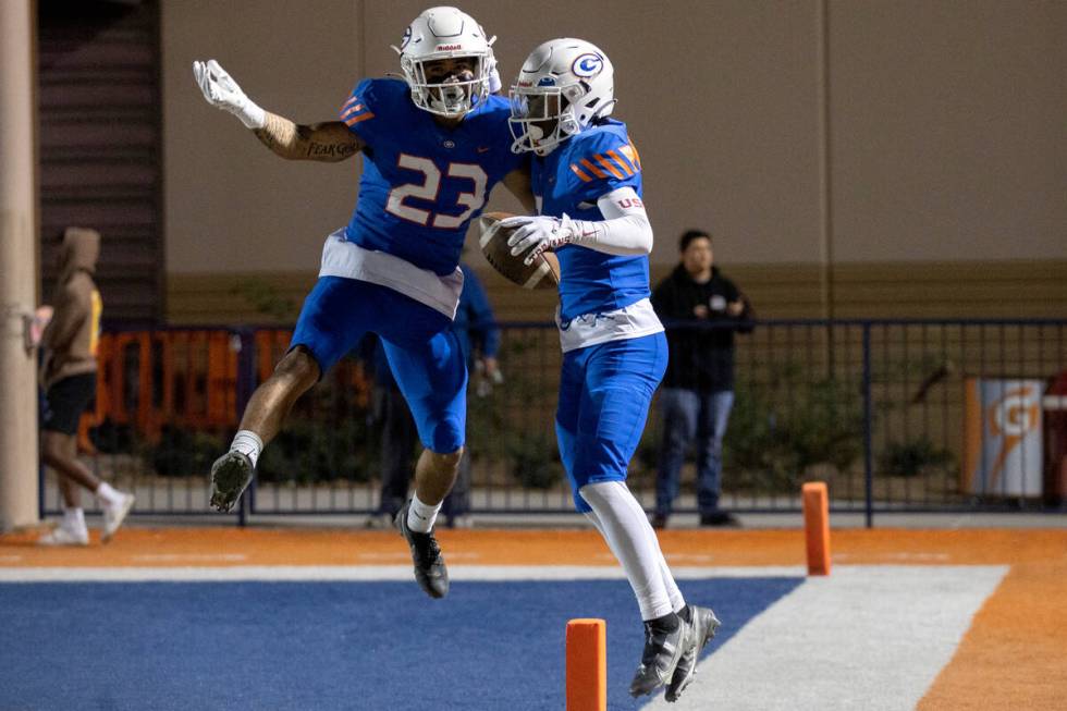 Bishop Gorman’s Trech Kekahuna (23) and Zachariah Branch (1) jump to celebrate Branch&#x ...