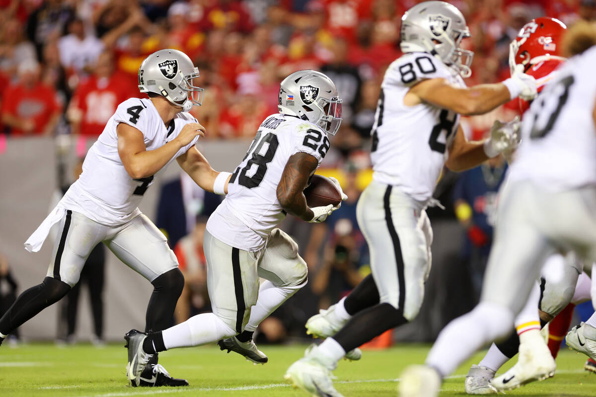 Raiders quarterback Derek Carr (4) hands off the ball to running back Josh Jacobs (28) for a ru ...