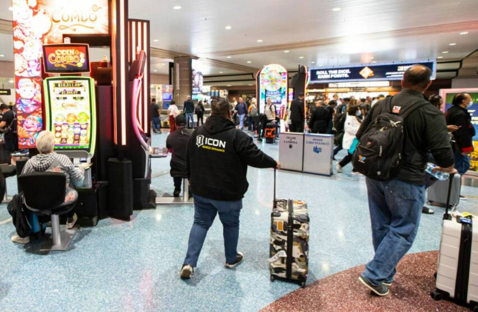 Travelers walk in the Terminal 1 baggage claim area at Harry Reid International Airport on Mond ...