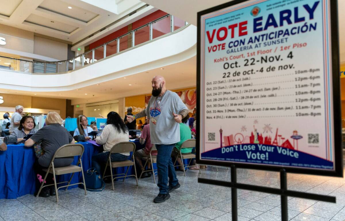 Poll worker Phil Hallond directs people at the polling place inside of the Galleria At Sunset s ...