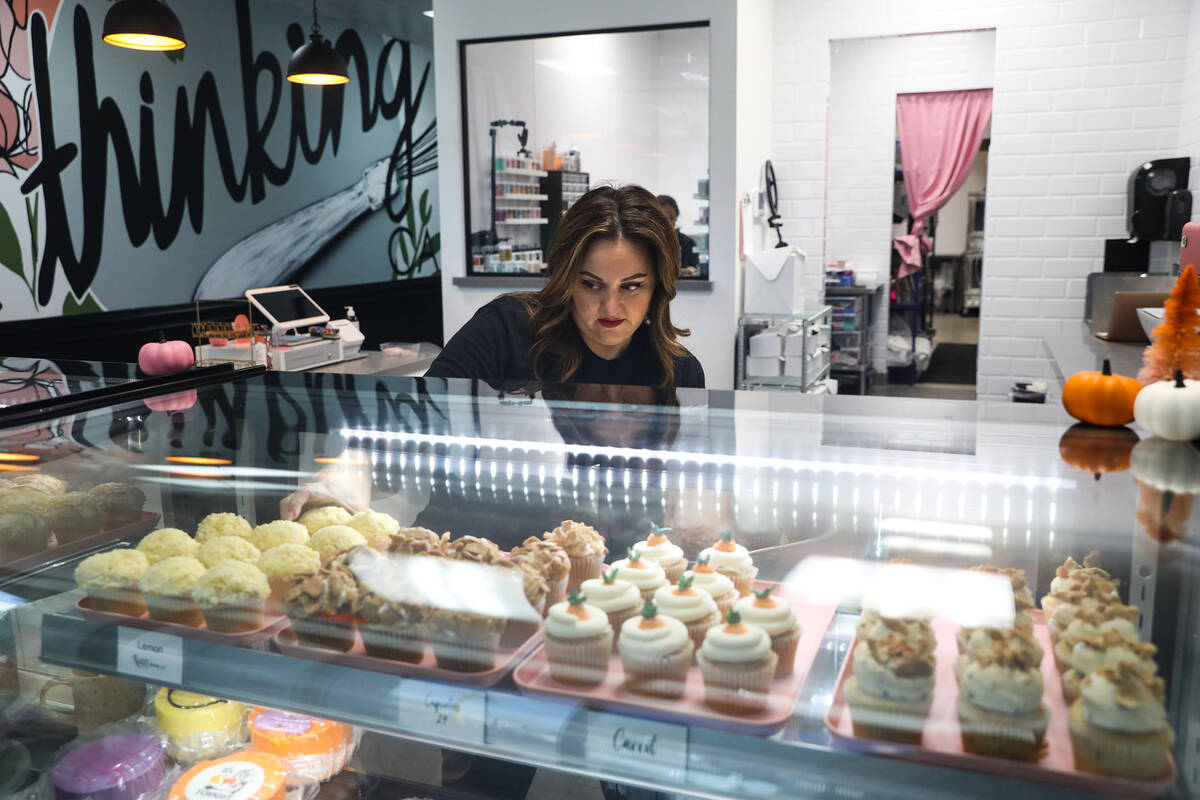 Co-owner Korey Wells sets out fresh cupcakes in the pastry case at Whiskful Thinking Cakes in L ...