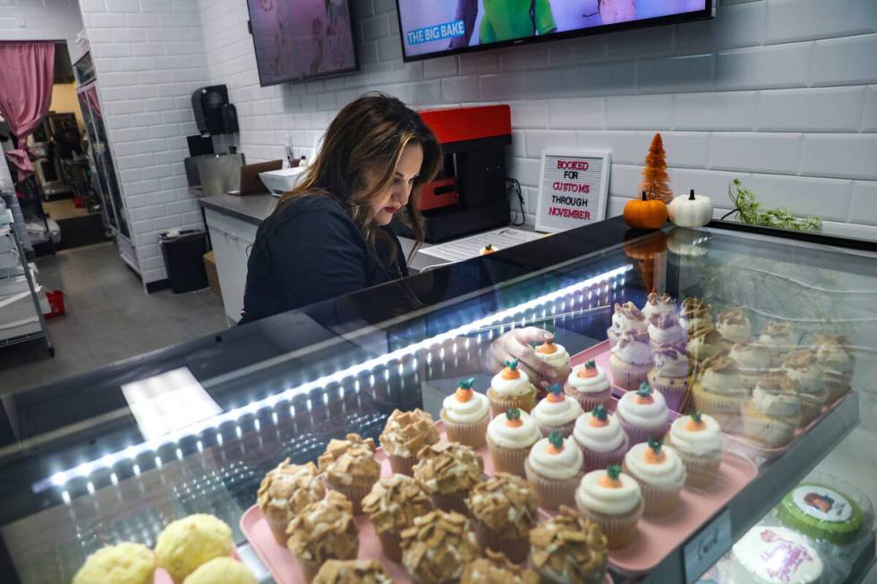 Co-owner Korey Wells sets out fresh cupcakes in the pastry case at Whiskful Thinking Cakes in L ...