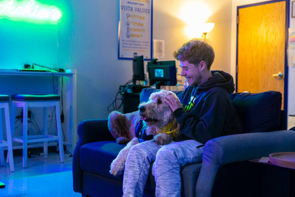 Sierra Vista High School junior Roman Dobos, 17, pets therapy dog Dood, a Goldendoodle, while i ...