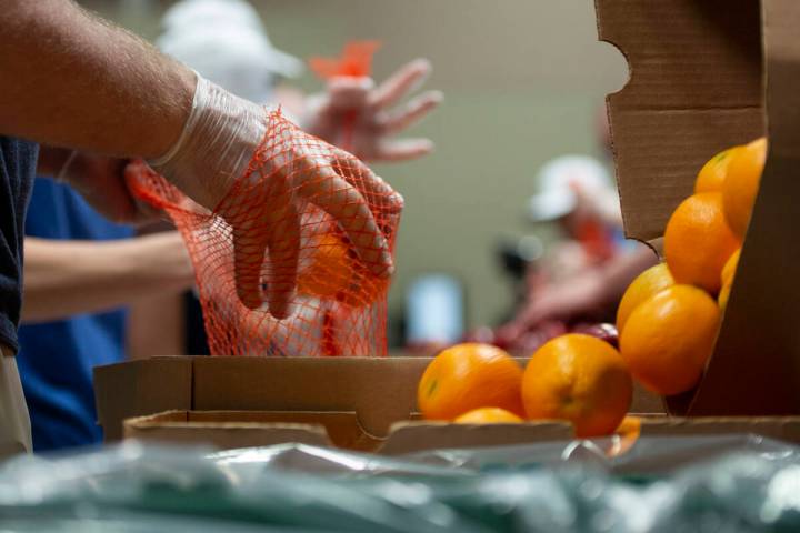 Volunteers help pack bags of fruit at the Three Square Food Bank. (Las Vegas Review-Journal file)