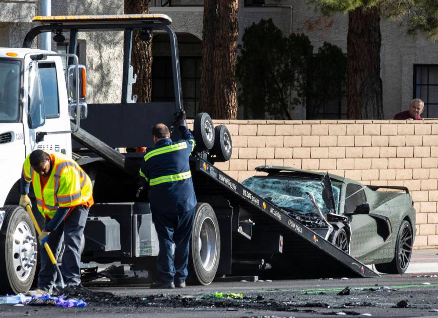 A nearby resident, right, watches as a towing company workers prepare to tow away Raiders wide ...