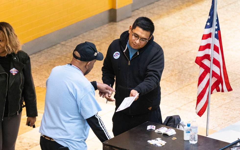 A Voter, who declined to give his name, prepares to place his ballot in an official mail-in bal ...