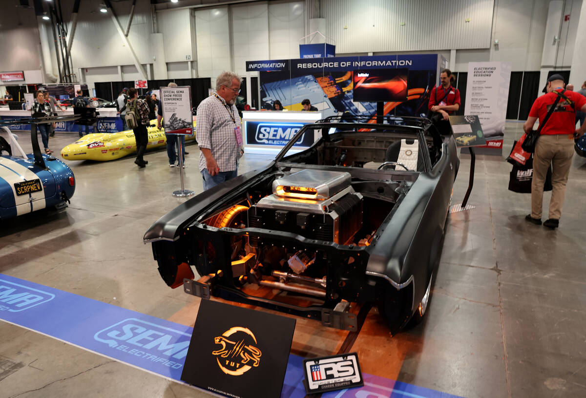 Conventioneers check out an all electric Mercury Cougar in the SEMA Electrified section on Day ...