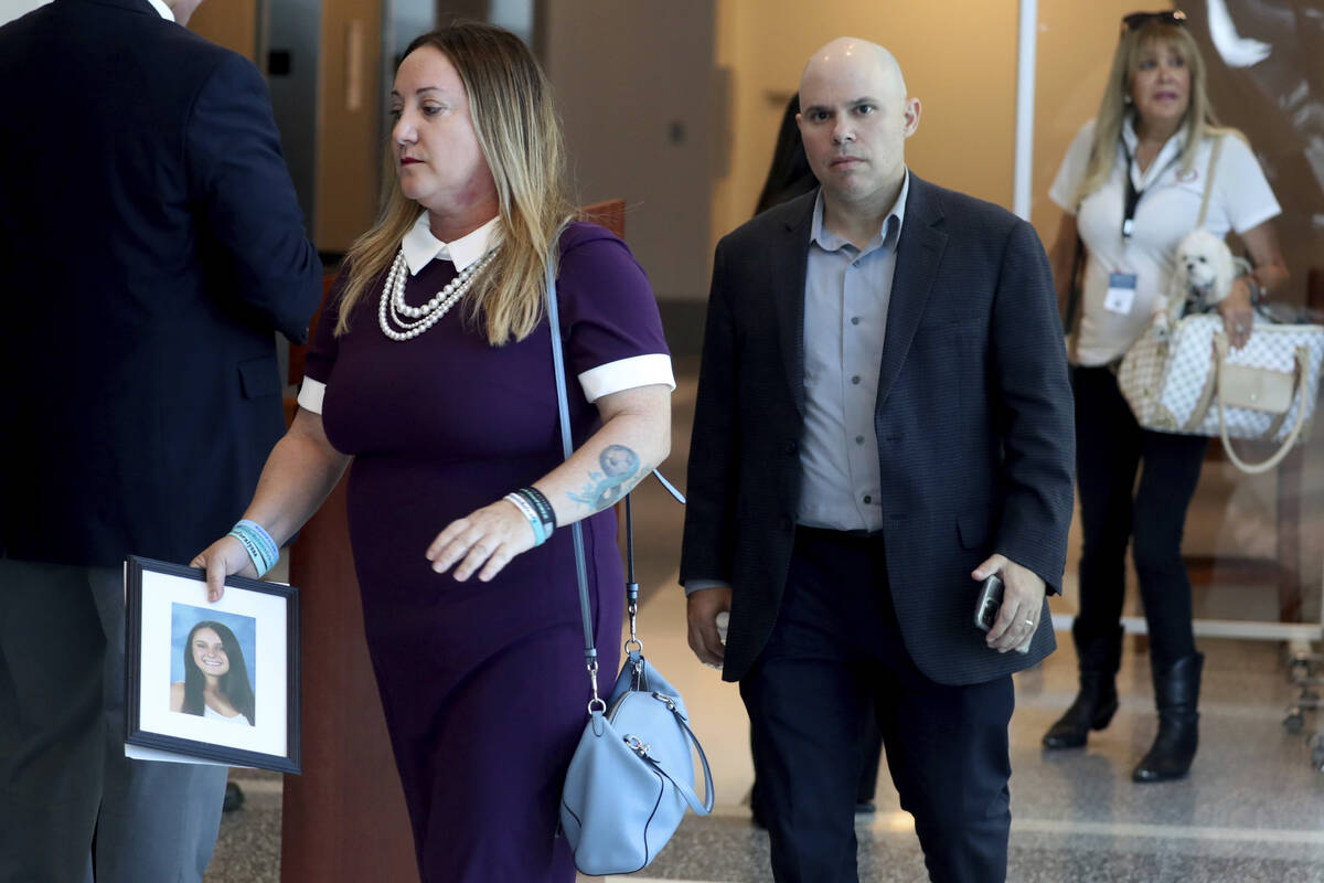 Lori Alhadeff, holding a photo of her daughter Alyssa, walks into court with her husband, Ilan ...