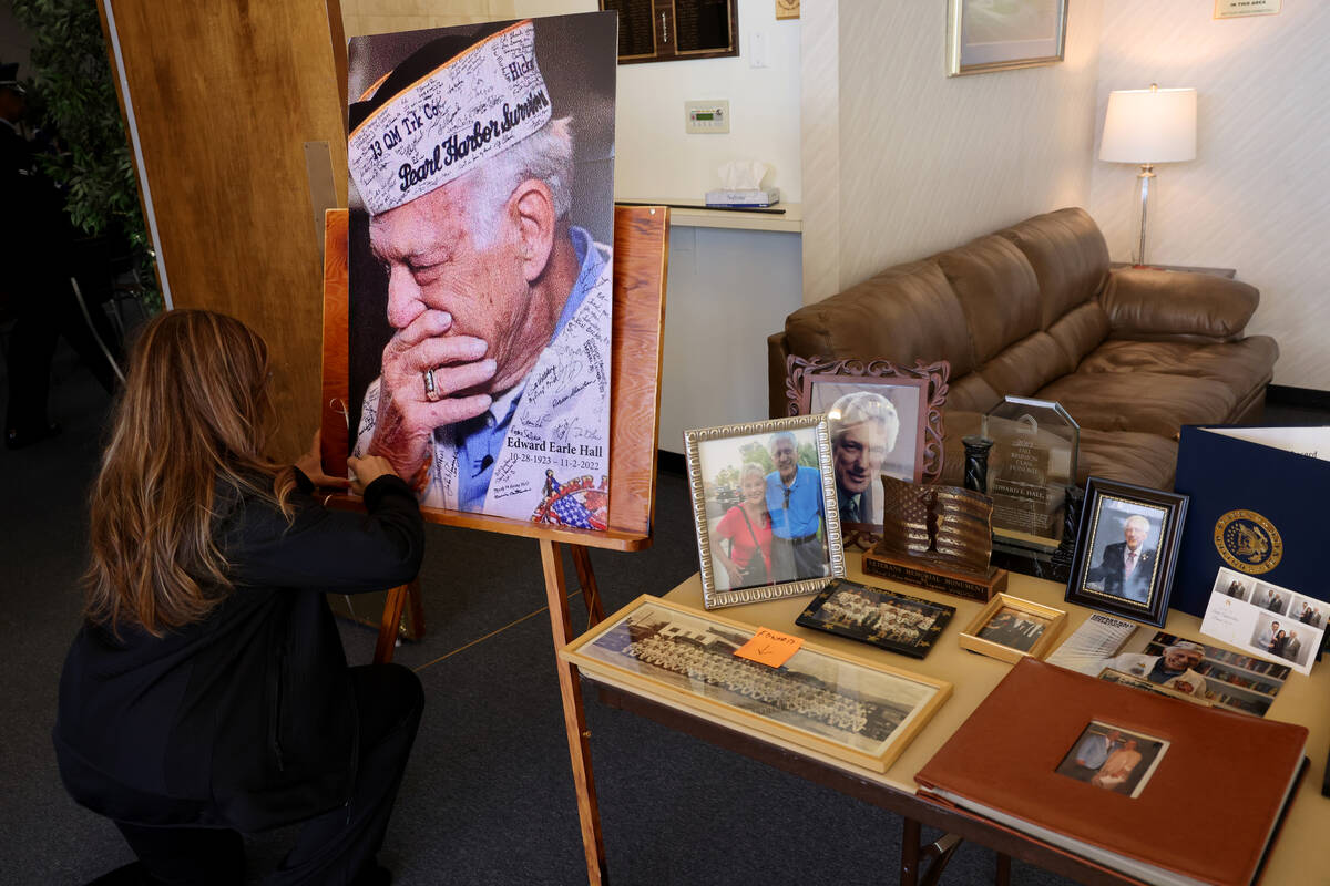 Gretchen Grierson with Honor Flight Southern Nevada signs a photo during a memorial service for ...