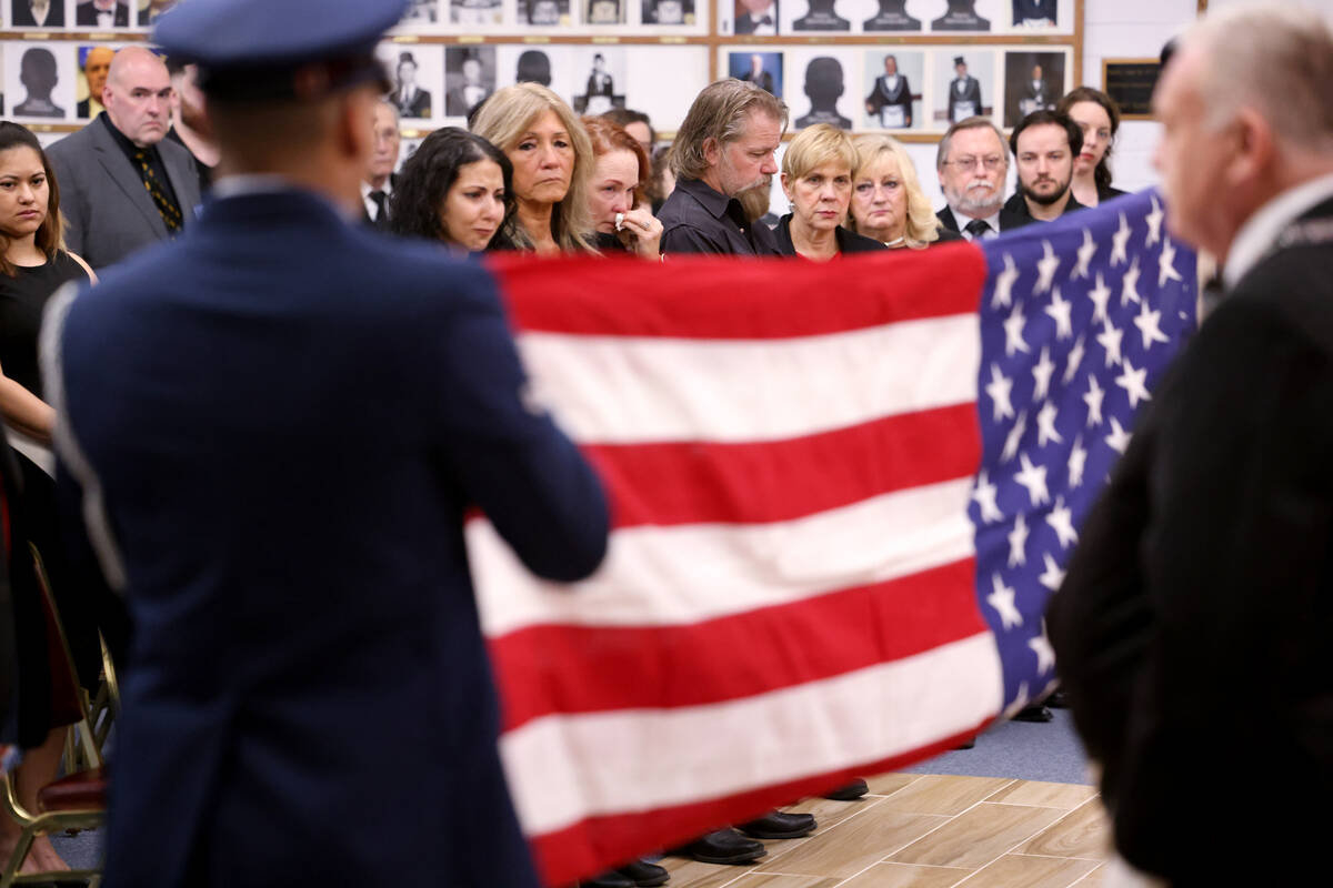 Loved ones of Ed Hall watch as an American Flag is folded during a memorial service for the Pea ...