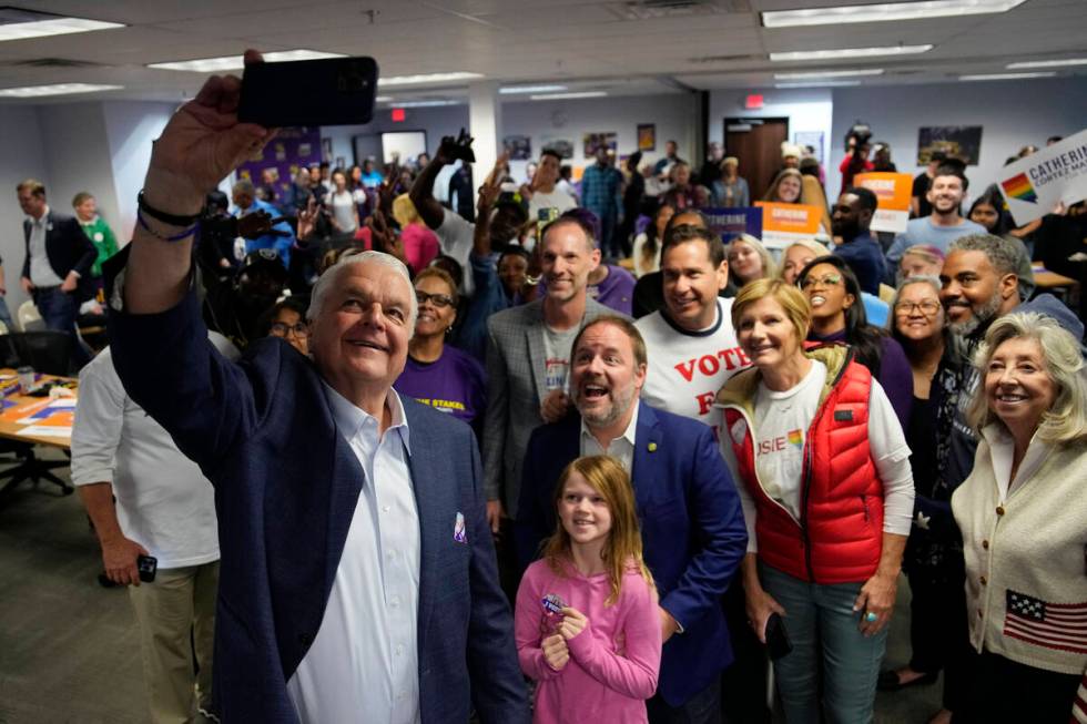 Nevada Gov. Steve Sisolak, left, takes a selfie with other candidates and supporters during a c ...