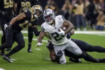 Raiders running back Josh Jacobs (28) is tackled by New Orleans Saints defensive tackle Kentavi ...