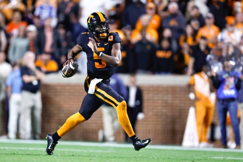 Tennessee quarterback Hendon Hooker (5) rolls out to pass during the first half of an NCAA coll ...