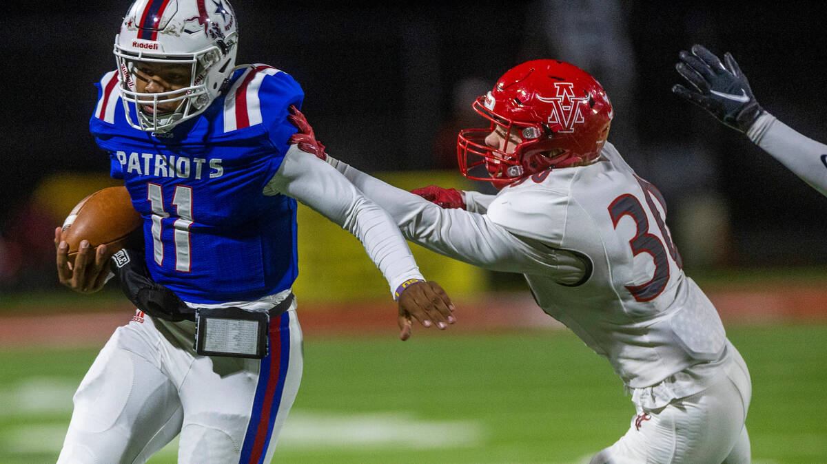 Liberty QB Tyrese Smith (11) fights for yards on a run over Arbor View SS Hayden Hartner (30) d ...