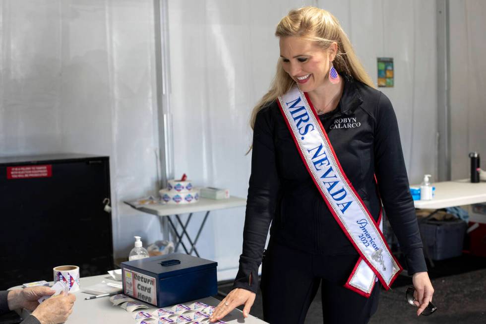 Robyn Calarco, Mrs. Nevada American 2022, takes an I Voted sticker after casting her ballot on ...